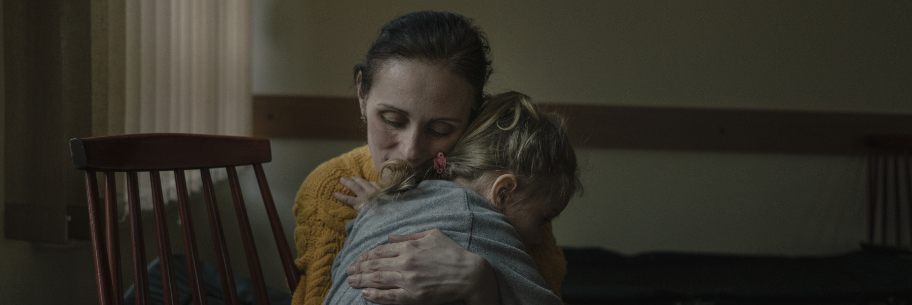 Mamma ucraina abbraccia la figlia, foto da un progetto sul territorio